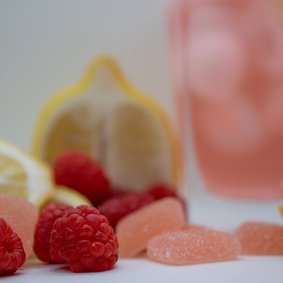 Uplift+ Daytime Gummies displayed with fresh raspberries and lemon slices, highlighting flavorful ingredients.